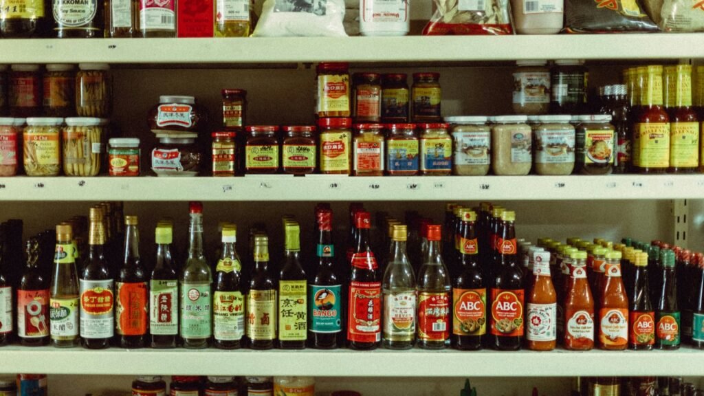 Grocery store shelves stocked with imported sauces, condiments, and pantry items
